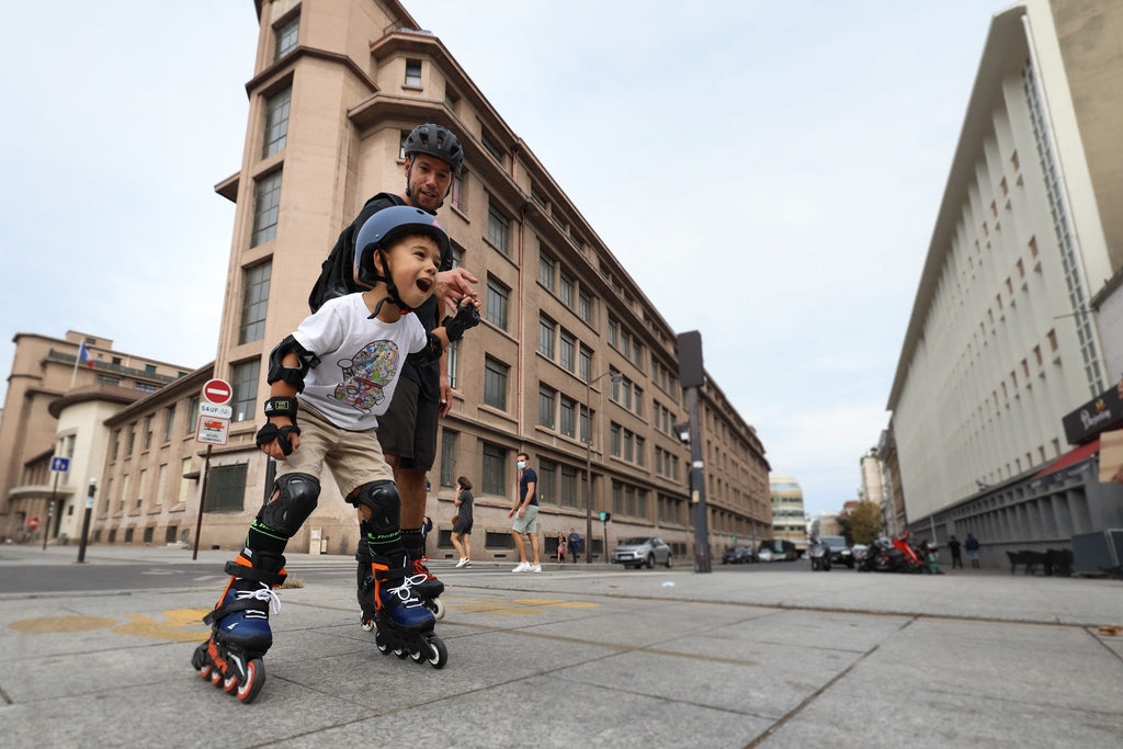 father and son inline skating in the city with rollerblades skates, helmet and protective gear